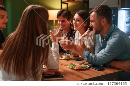Group of people are on the kitchen, having dinner, spending time together Group of people are on the kitchen, having dinner, spending time together 127364165