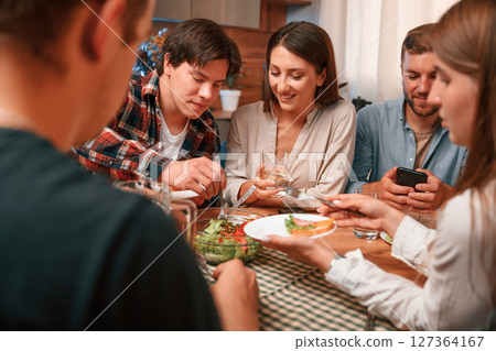 Delicious food. Group of people are on the kitchen, having dinner, spending time together 127364167