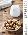 Dry breakfast cereals. Chocolate and corn rings made from natural cereals with milk in a plate. Wooden rustic background, copy space. 127364404