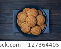 Natural homemade oatmeal cookies on a plate, dark wooden background, copy space. 127364405