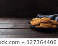 Natural homemade oatmeal cookies on a plate, dark wooden background, copy space. 127364406