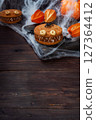 Cookies with cream paste in the shape of monsters for Halloween celebration. Funny homemade faces made of oatmeal cookies and boiled condensed milk. copy space 127364412