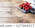 handful Juicy ripe strawberries on a wooden rustic background. Sweet healthy dessert, vitamin harvest. copy space. 127364417