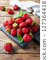 handful Juicy ripe strawberries on a wooden rustic background. Sweet healthy dessert, vitamin harvest. copy space. 127364418