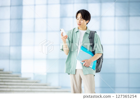 College student with smartphone in office lobby 127365254