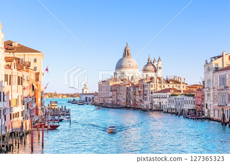 Amazing view of Grand Canal with palaces, gondolas and boats and Basilica Santa Maria della Salute during sunset in Venice, Italy. Amazing view of Grand Canal with palaces, gondolas and boats and Basilica Santa Maria della Salute during sunset in Venice, Italy. 127365323