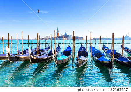 Gondolas on the Grand canal in Venice, Italy. In background, on island of San Giorgio, is the Church of San Giorgio Maggiore with bell tower. Gondolas on the Grand canal in Venice, Italy. In background, on island of San Giorgio, is the Church of San Giorgio Maggiore with bell tower. 127365327