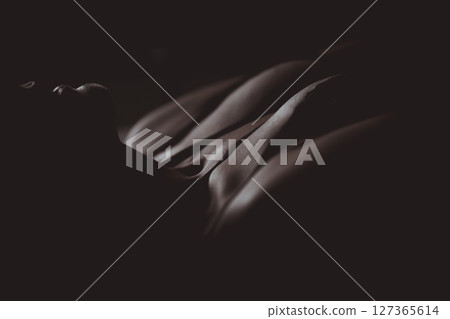 Beautiful naked female body on a black background. Young sensual slender girl in black lingerie. Sexy body close up nudity Beautiful naked female body on a black background. Young sensual slender girl in black lingerie. Sexy body close up nudity 127365614