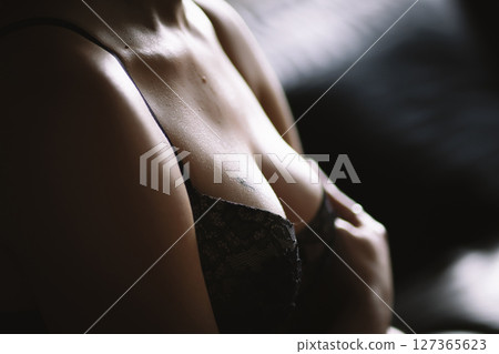 Beautiful naked female body on a black background. Young sensual slender girl in black lingerie. Sexy body close up nudity 127365623