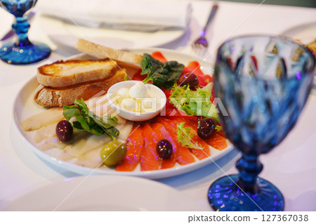 fish cut, butter and toast on a plate.  127367038