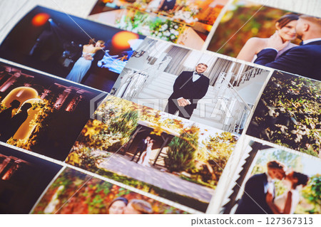 Printed wedding photos laid out on a wooden surface. Printed wedding photos laid out on a wooden surface. 127367313