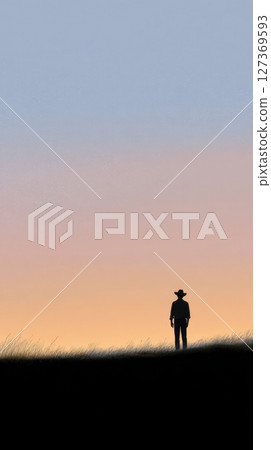 Cowboy boy stands as a silhouette, watching the sunset paint the sky over expansive ranch plains 127369593
