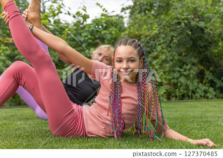 Closeup view of young girl and mature woman exercising  gymnastics 127370485