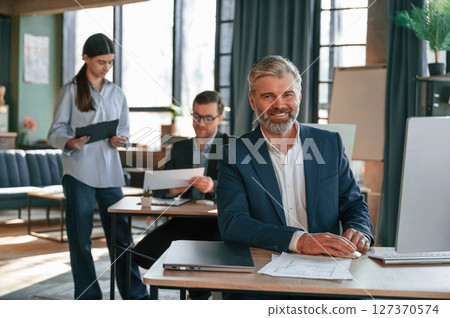 Man is smiling. Group of business people are working in the modern office 127370574