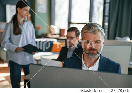 Using computer. Group of business people are working in the modern office 127370586