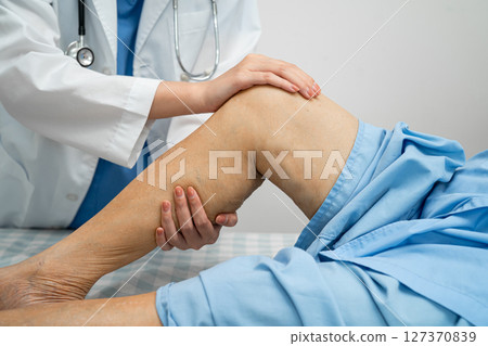 Doctor checking Asian elderly woman patient with scar knee replacement surgery in hospital. Doctor checking Asian elderly woman patient with scar knee replacement surgery in hospital. 127370839