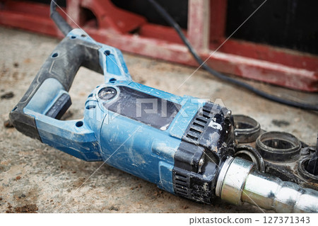 Power tool on a construction site showing wear and dirt after heavy use during a project in progress Power tool on a construction site showing wear and dirt after heavy use during a project in progress 127371343