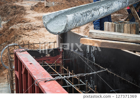 Concrete pouring process at construction site during daylight hours in urban area Concrete pouring process at construction site during daylight hours in urban area 127371369