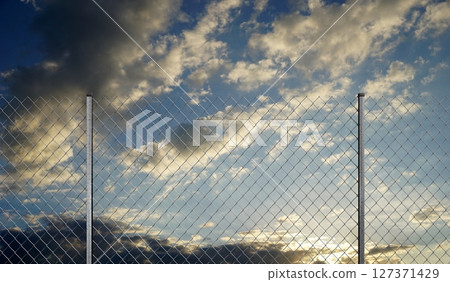 Mesh wire fence and sunset sky - 3d illustration 127371429