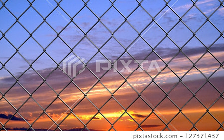Mesh wire fence and sunset sky - 3d illustration 127371437