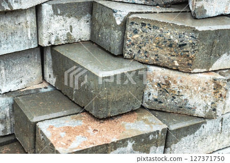 Stacked concrete bricks in a construction site during daylight hours in an urban environment Stacked concrete bricks in a construction site during daylight hours in an urban environment 127371750