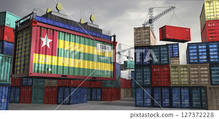 Cargo container with flag of Togo lifted by crane at freight terminal - 3D illustration 127372228