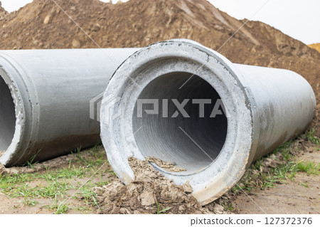 Reinforced concrete storm sewer pipes of large diameter stacked at a construction site. Sewer Large diameter pipes. Wastewater disposal in a modern city. 127372376