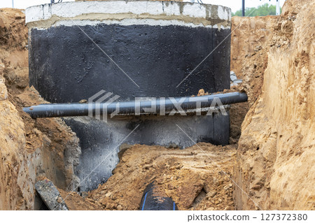 The high voltage electrical cable is laid in a trench under existing engineering sewerage networks. Laying a high voltage cable for supplying buildings with electricity. 127372380