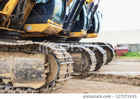 Two powerful excavators work at the same time on a construction site, sunny blue sky in the background. Construction equipment for earthworks. 127372433