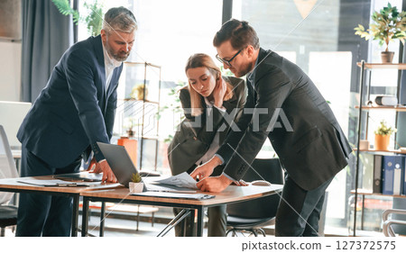 Standing by the table. Group of business people are working in the modern office 127372575