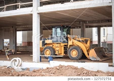 Construction machinery working on a site during the day in an urban area Construction machinery working on a site during the day in an urban area 127372758