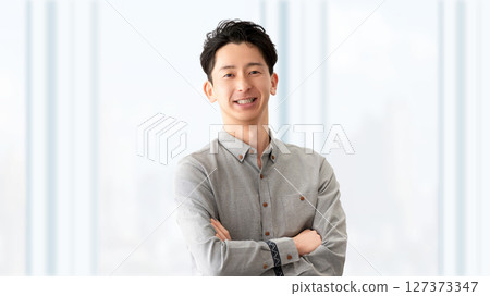 Smiling male businessman with arms folded Smiling male businessman with arms folded 127373347