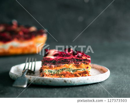 Vegetable Packed Rainbow lasagne on green background.Ideas and recipes for healthy vegetarian dinner or lunch.Lasagne with beetroot, pumpkin, mushrooms, ricotta, spinach, mozarella.Copy space for text Vegetable Packed Rainbow lasagne on green background.Ideas and recipes for healthy vegetarian dinner or lunch.Lasagne with beetroot, pumpkin, mushrooms, ricotta, spinach, mozarella.Copy space for text 127373503