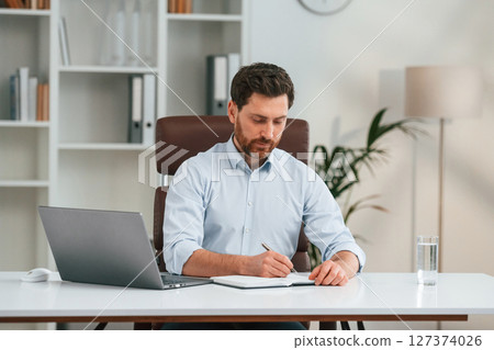 Doctor in formal clothes is working in the cabinet 127374026