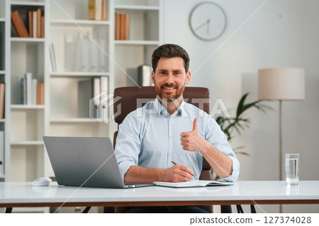 Front view. Doctor in formal clothes is working in the cabinet 127374028
