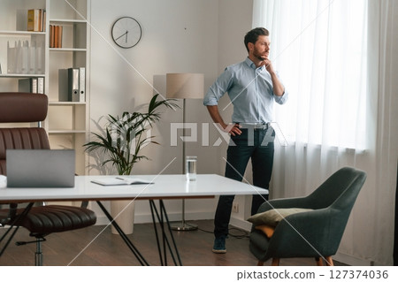 Walking, thinking, waiting for patient. Doctor in formal clothes is working in the cabinet 127374036