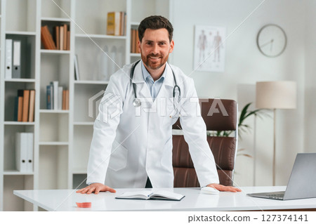 Standing in the office. Doctor in formal clothes is working in the cabinet 127374141