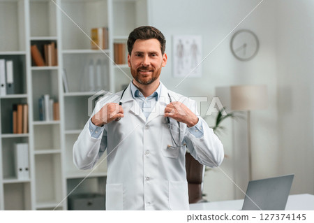 With stethoscope. Doctor in formal clothes is working in the cabinet 127374145