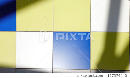 Colorful Tiled Floor With Shadows in a Brightly Lit Indoor Space During the Day 127374440