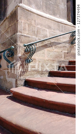 Old Stone Stairs With Ornate Railings Leading to a Historic Building Entrance in Bright Sunlight 127374494