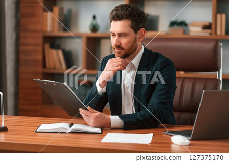 Working with documents. Businessman in formal clothes is indoors 127375170