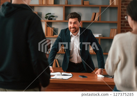 The boss shouts at subordinates. Businessman in formal clothes is working indoors The boss shouts at subordinates. Businessman in formal clothes is working indoors 127375285