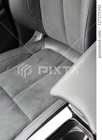 Dents and scuffs on the leather surface of a car seat trimmed with leather and alcantara Dents and scuffs on the leather surface of a car seat trimmed with leather and alcantara 127375342