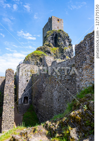 Panna Tower rises above the ancient ruins of Trosky Castle in Bohemian Paradise, Czechia. Visitors enjoy the scenic beauty and rich history of this captivating location on a clear day. Panna Tower rises above the ancient ruins of Trosky Castle in Bohemian Paradise, Czechia. Visitors enjoy the scenic beauty and rich history of this captivating location on a clear day. 127375550