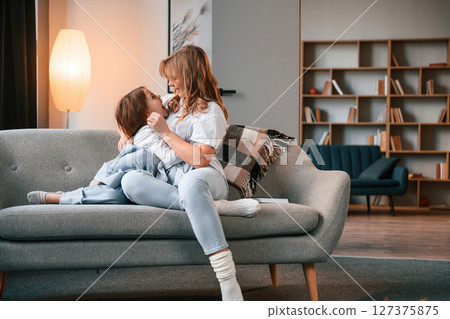 Having fun, embracing. Mother with her little daughter is together in domestic room Having fun, embracing. Mother with her little daughter is together in domestic room 127375875