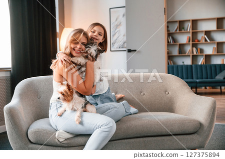 Mother with her daughter and with cute dog is in domestic room Mother with her daughter and with cute dog is in domestic room 127375894