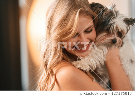 Beautiful young woman is with little dog indoors Beautiful young woman is with little dog indoors 127375913