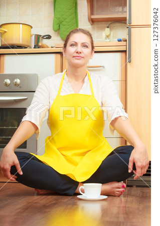 Mature woman with cup of coffee in kitchen. Mature woman with cup of coffee in kitchen. 127376042