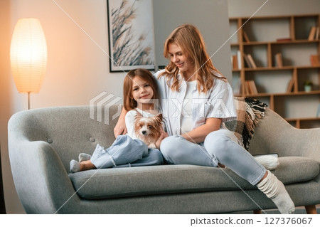 Beautiful animal. Mother with her daughter and with cute dog is in domestic room Beautiful animal. Mother with her daughter and with cute dog is in domestic room 127376067