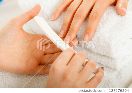 Woman getting manicure done file nails 127376204